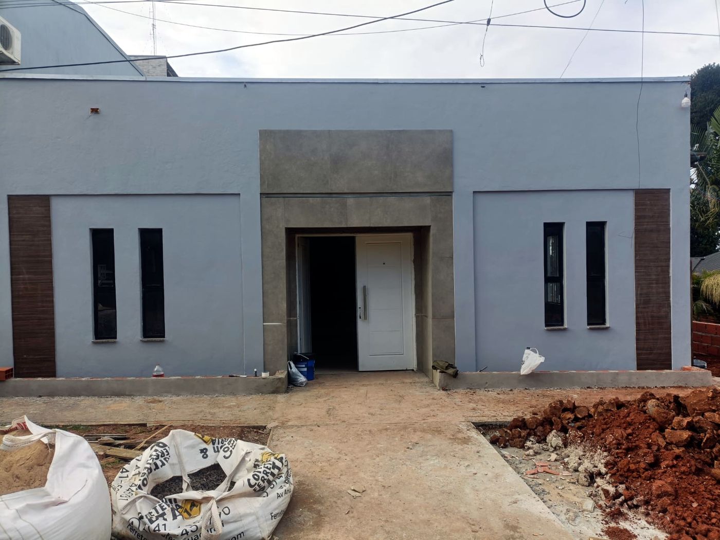 El frente pintado, con puerta, ventanas y revestimiento del pórtico
